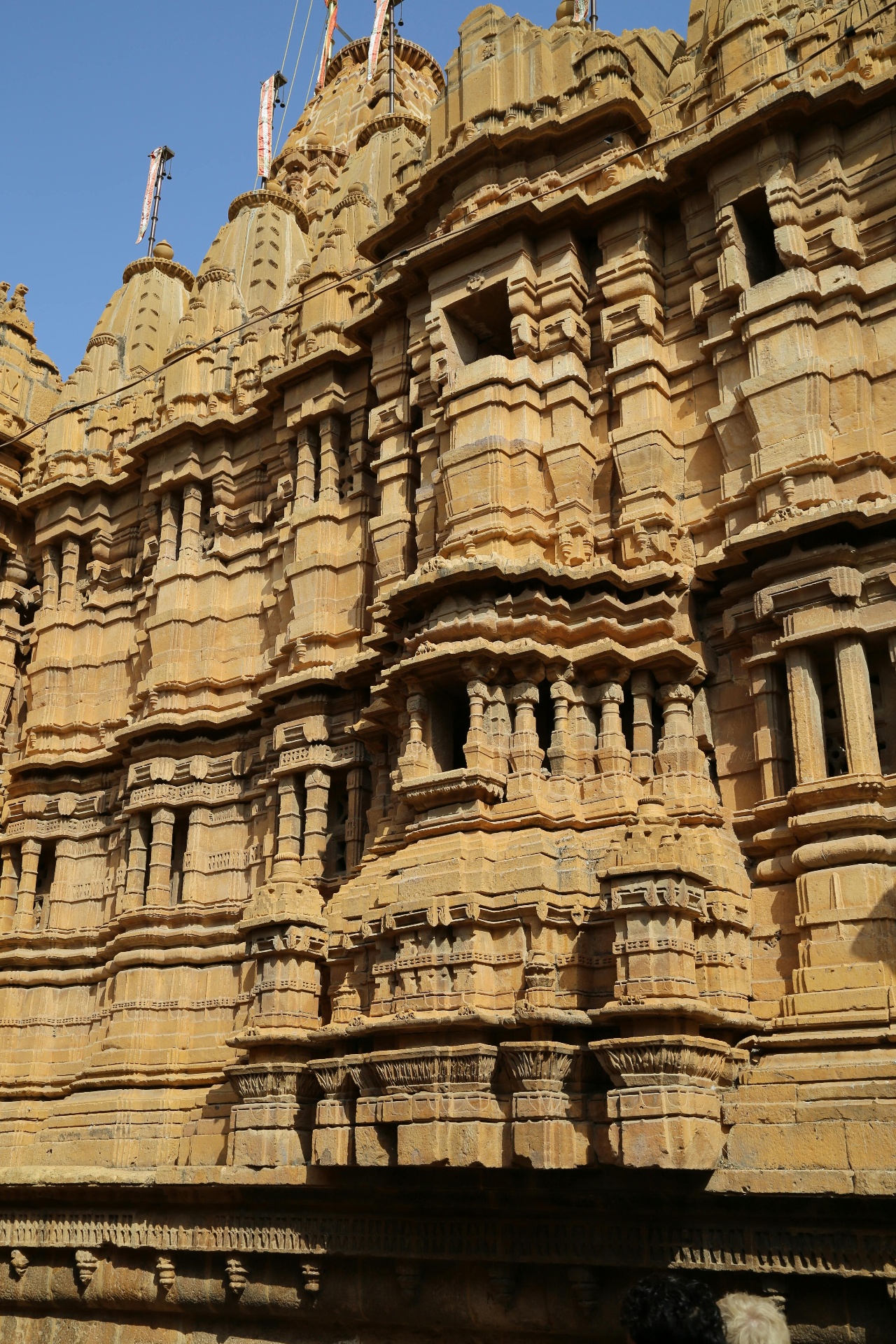 Hand-carved yellow sandstone facade of a Jain temple in Jaisalmer, layered with intricate stonework